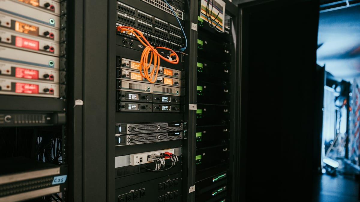 Racks of server hardware in a dim, considered data room