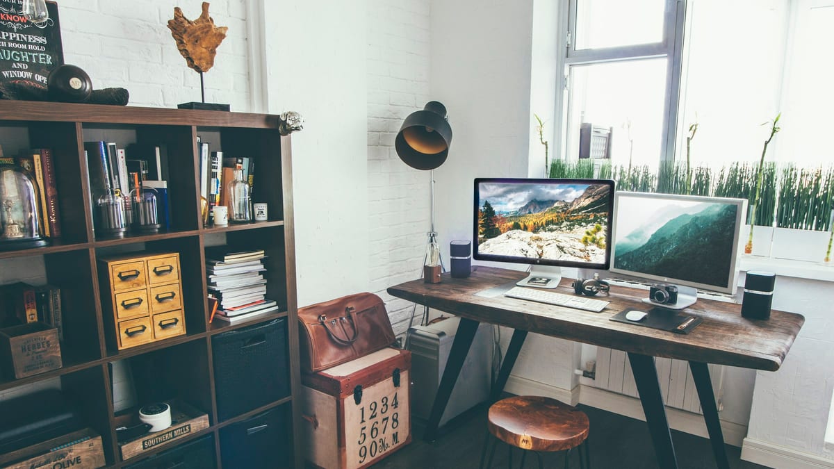 A quiet desk workspace with dual monitors and organised documents